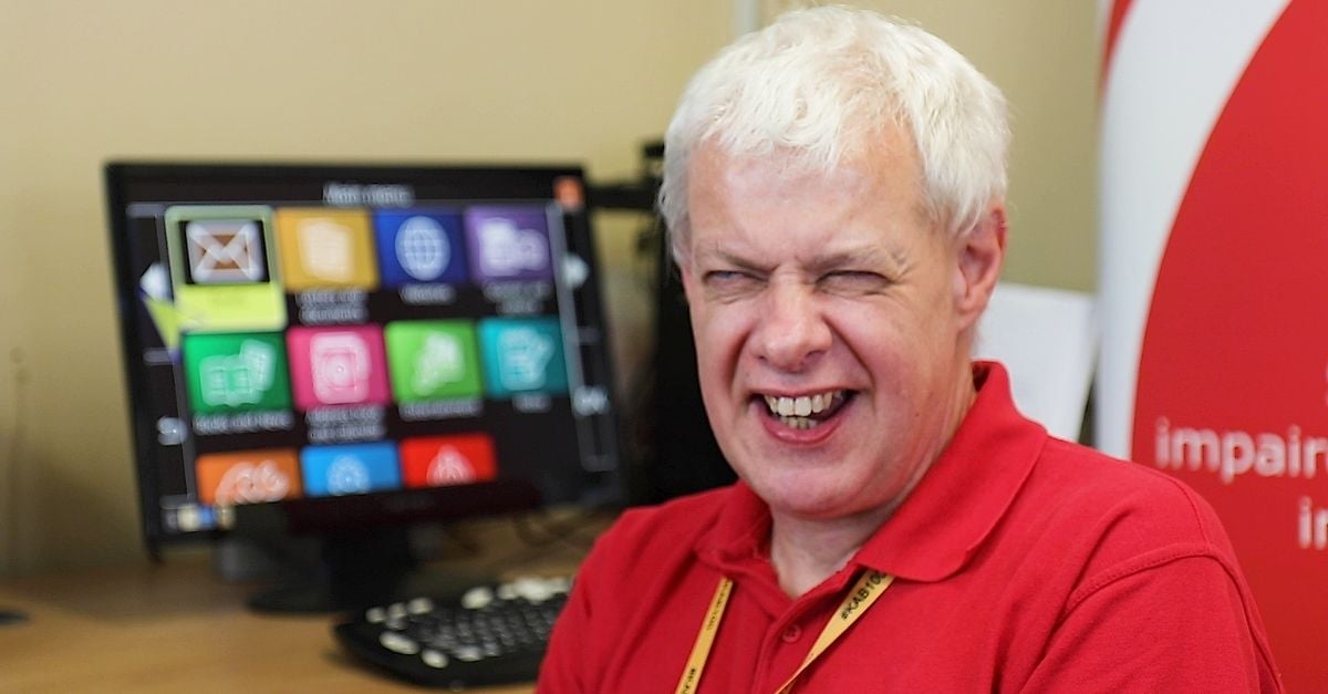 Steve from the KAB sitting in front of a desk where his computer displays the GuideConnect interface